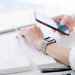 Person nutzt Smartphone und Smartwatch am Schreibtisch | Elf Bar Vape